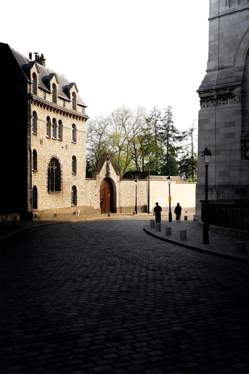 A stone building with a clock tower in the background